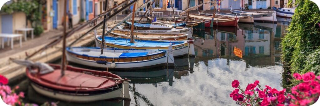 Façades colorées et barques de pêcheurs se reflétant dans le Miroir aux Oiseaux à Martigues.